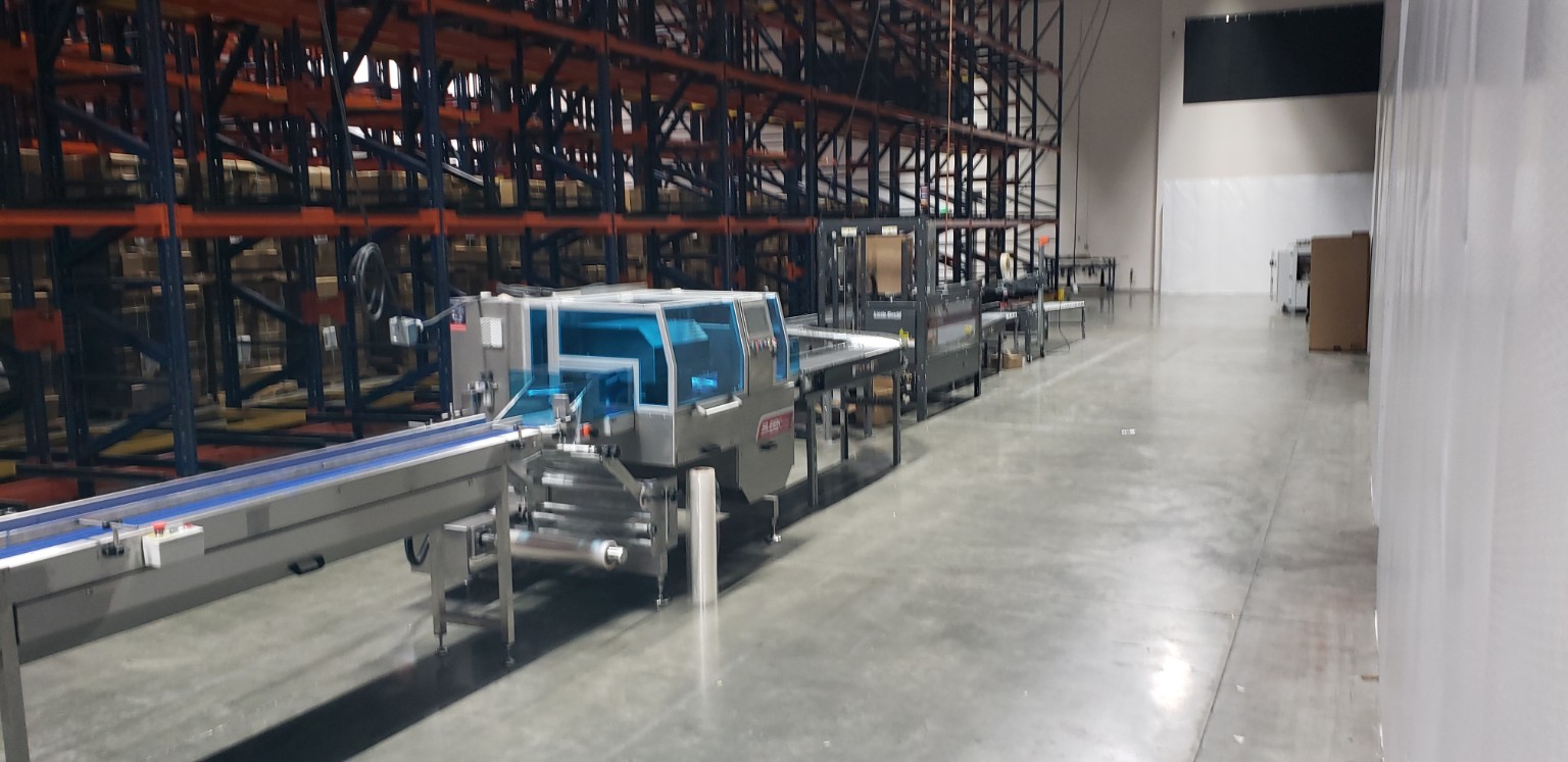 Integrated conveyor and packaging line in a warehouse