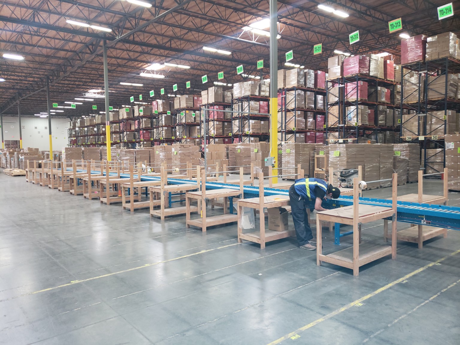 Warehouse conveyor line serving multiple packing stations