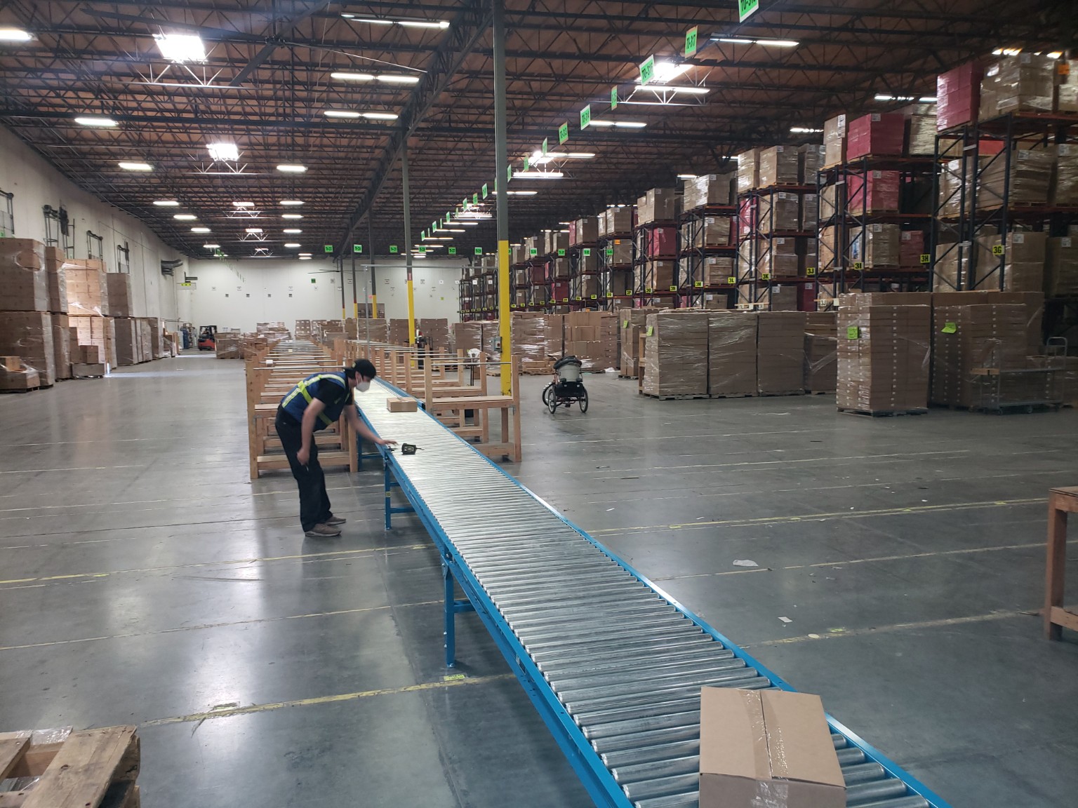 Long roller conveyor installation in an active warehouse